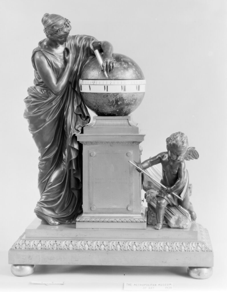 Black-and-white photograph of the Pendule Clio: a draped muse leaning on a globe set with a dial, with a small winged figure at her feet, on a stepped base
