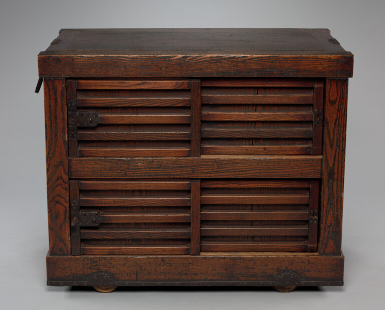 Dark wooden chest with two tiers of louvered doors, a deep plank lid, iron hinges and a heavy base set on wheels
