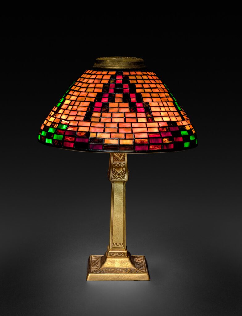 Conical leaded-glass shade of orange, red and green rectangles in a basket-weave pattern, on a slim gilt-bronze base with a square foot