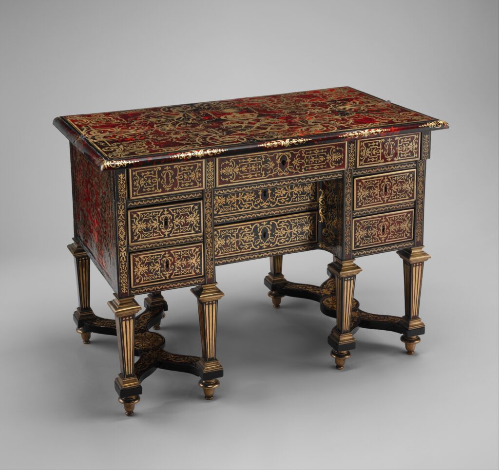 Small desk inlaid in red tortoiseshell and brass, with banks of drawers on either side of a central recess and turned legs joined by an X-shaped stretcher
