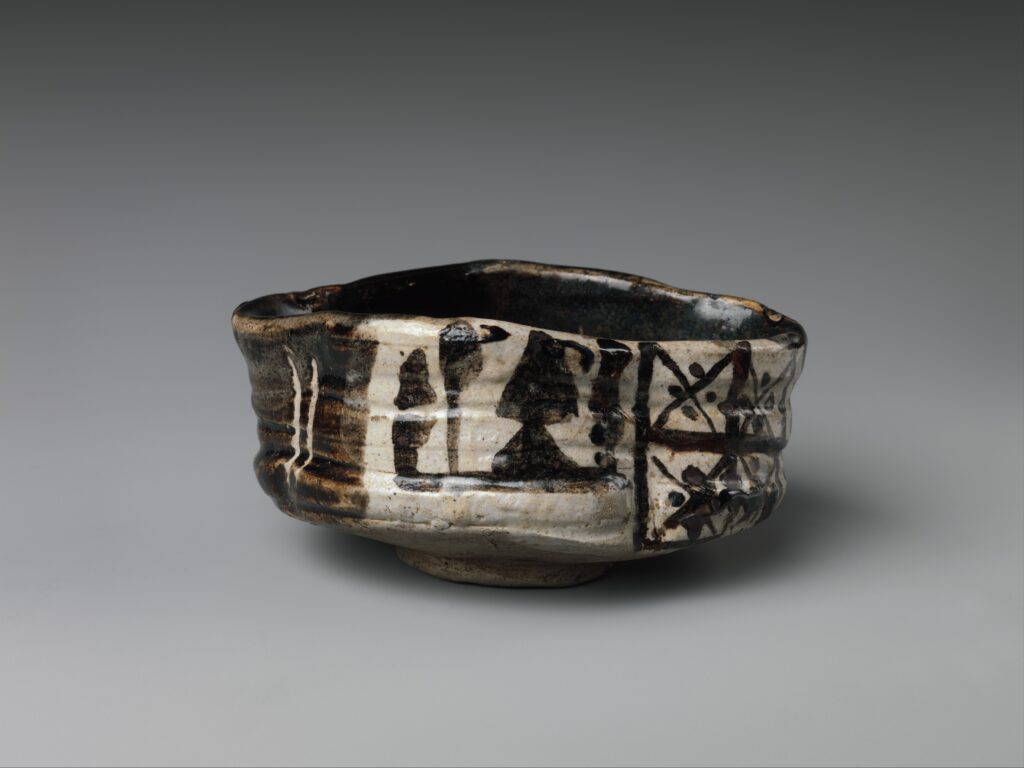 Clog-shaped chawan in Black Oribe ware, an irregular tea bowl with plum blossom and grid patterns in white slip and iron black