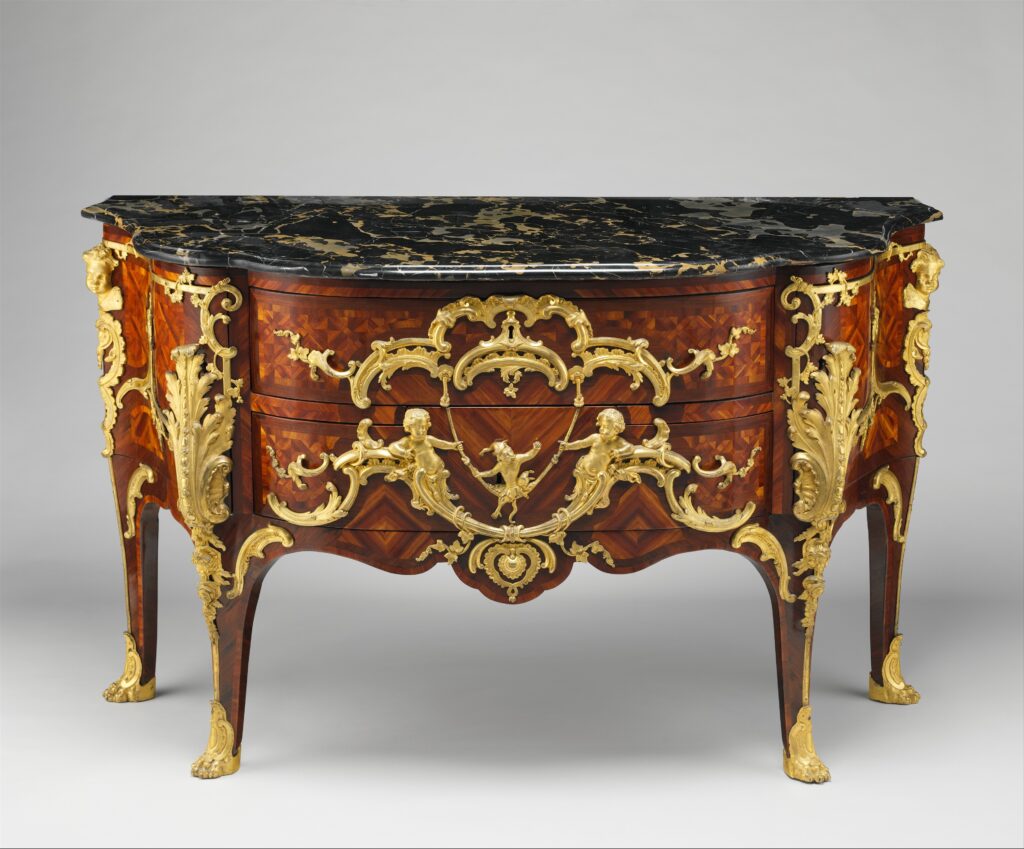 Curved French commode whose drawers and sides are covered in diamond-shaped parquetry, with gilt-bronze mounts and a dark marble top