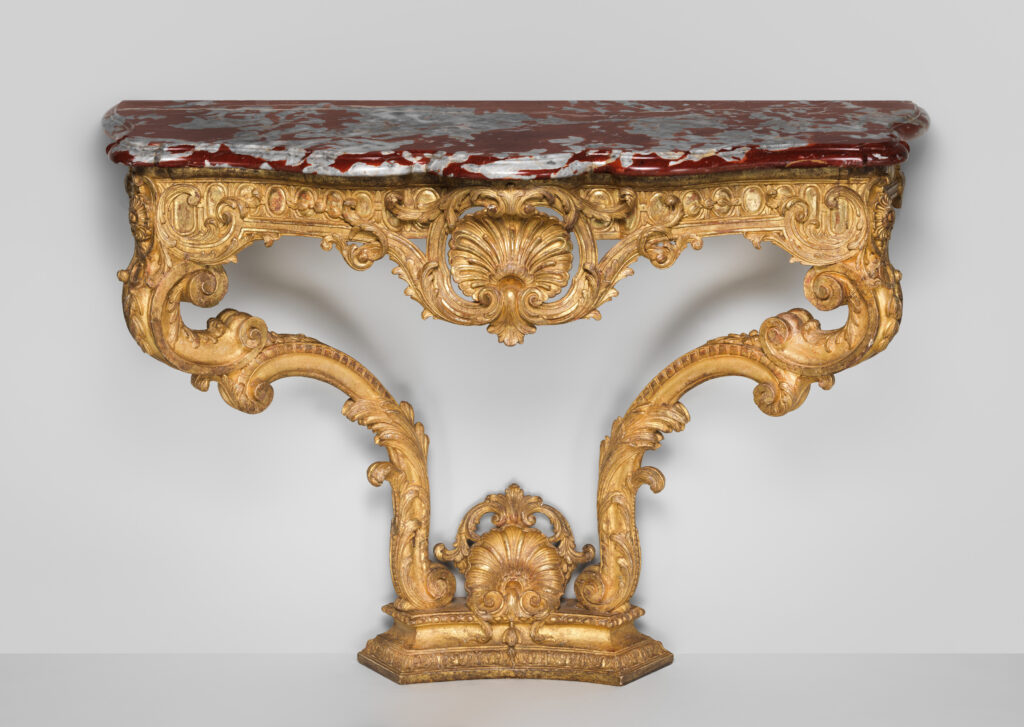 Antique French console table in gilded wood with a red-veined marble top, a shell at the centre of a carved apron and two sweeping scrolled legs joined by a stretcher with a shell