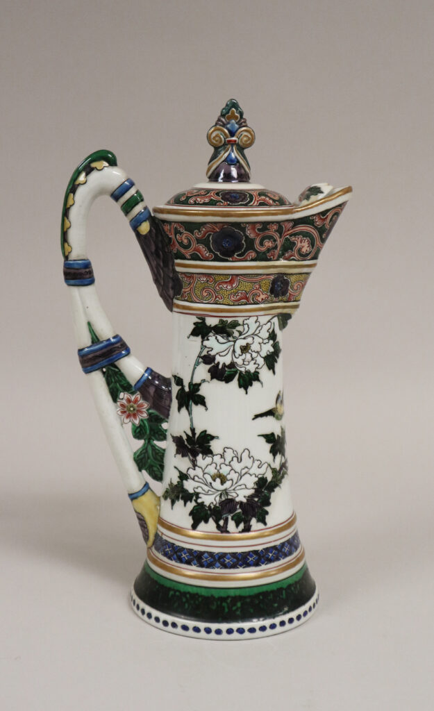 White porcelain ewer with a lid, painted with peonies and a bird, with bands of gold, blue and green and a tall curved handle