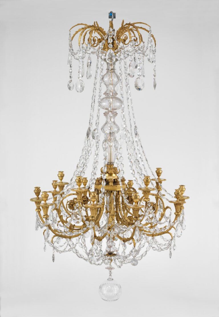 Gilt-bronze chandelier with fifteen candle arms curving out from a glass-covered central shaft, hung with strings of glass drops and a large glass ball at the base