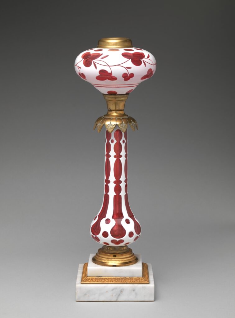 Tall fluid lamp with a pink and white cut overlay glass font and stem, brass fittings and a stepped marble base