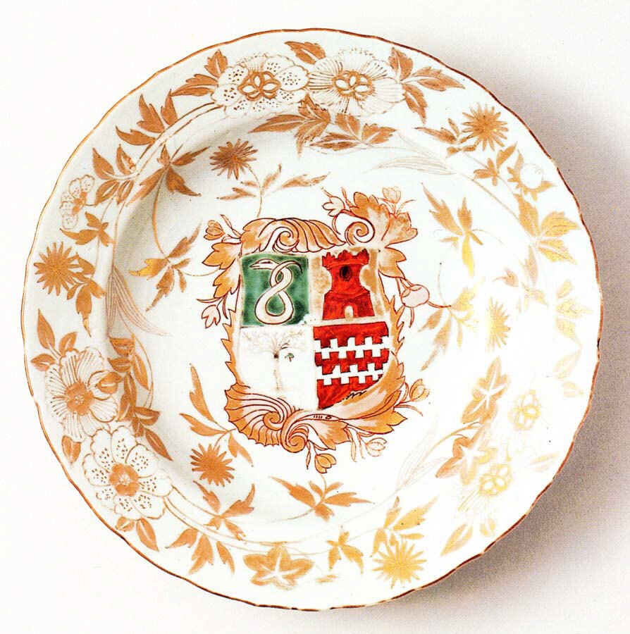 Imari plate with a coat of arms at the center, a shield with a red tower, surrounded by orange and gold flower sprays