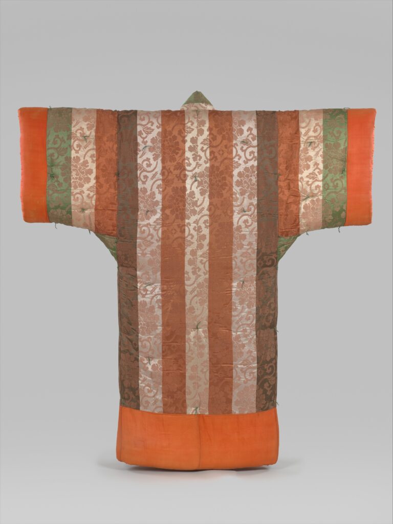 Padded kimono-shaped comforter seen from behind, in vertical stripes of patterned cream, rust and green silk with orange sleeves and hem