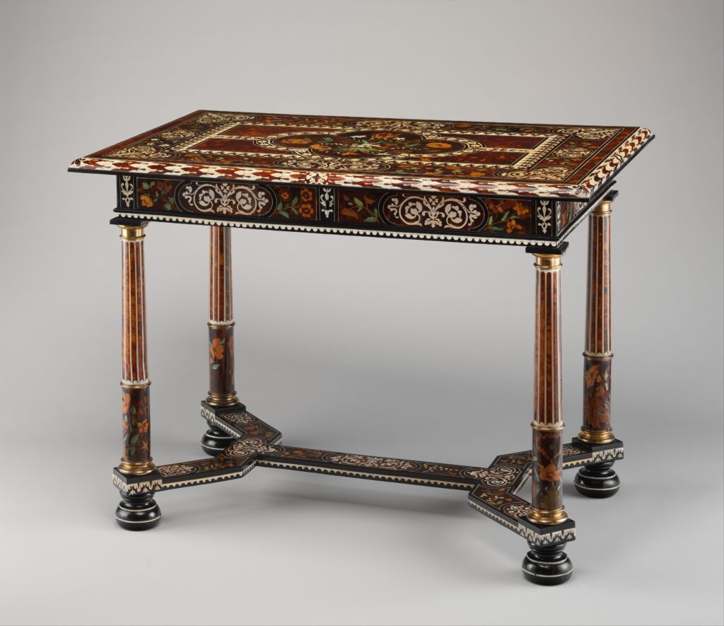Low table with a top inlaid in tortoiseshell, ivory and ebony in a dense pattern of flowers and scrolls, on columnar legs joined by a stretcher