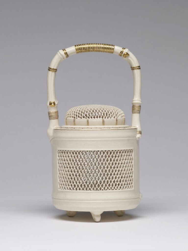 Cream Satsuma incense burner with a bamboo-shaped handle over an openwork lid, a pierced lattice body and three small feet, with gold bands on the handle