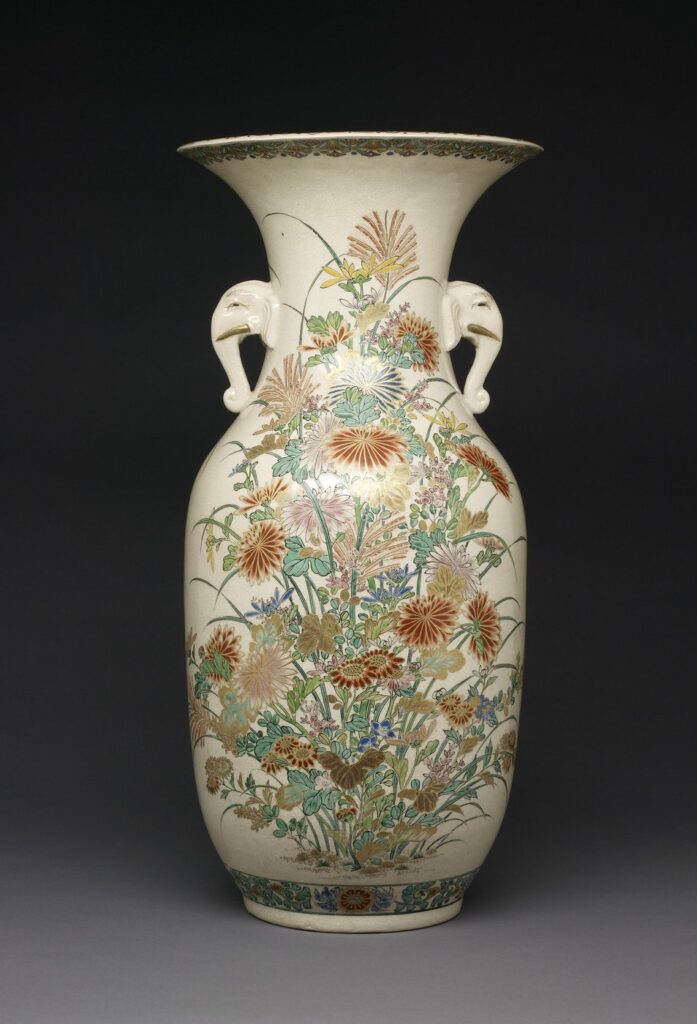 Tall cream Satsuma vase with elephant-head handles, painted all over with chrysanthemums and autumn flowers in orange, green and gold