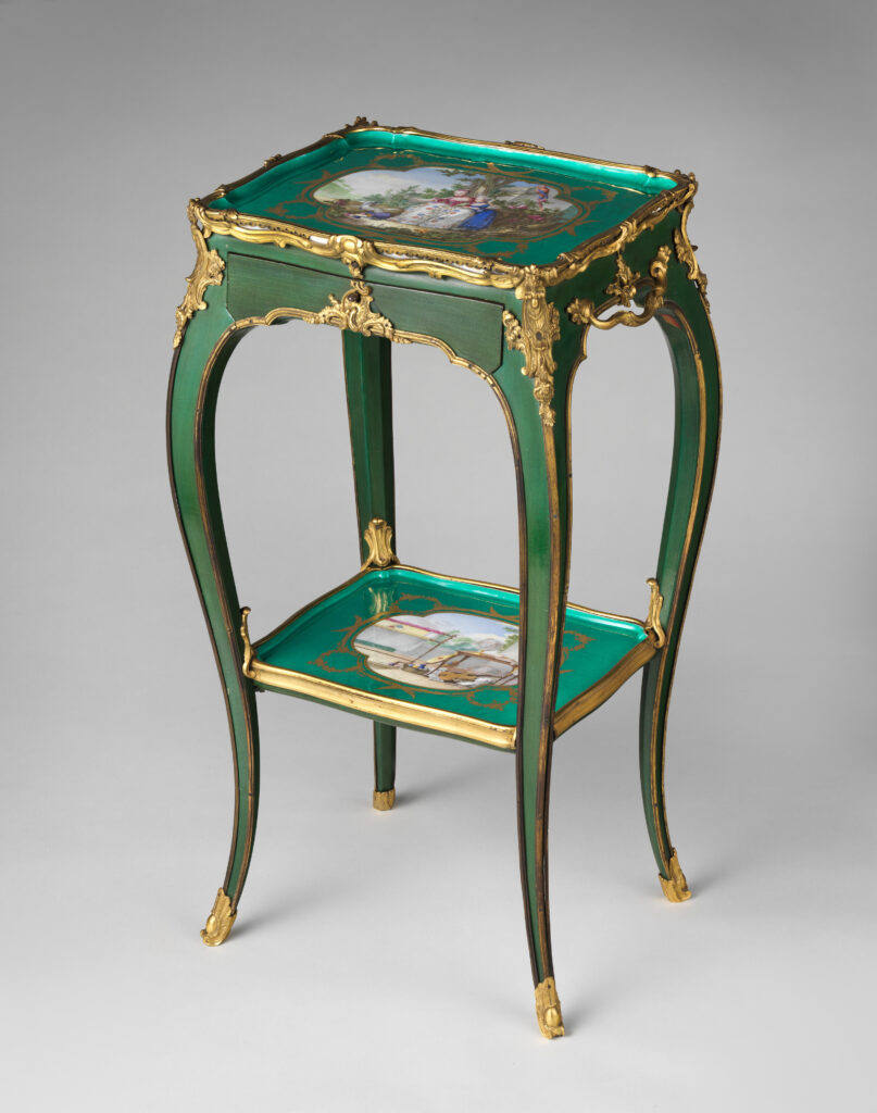 Slender green table with curved legs, gilt-bronze mounts and two porcelain trays painted with figures, one forming the top and one a lower shelf